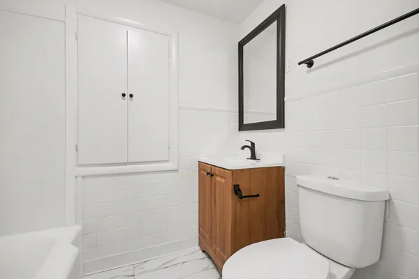 a bathroom with a toilet sink and mirror