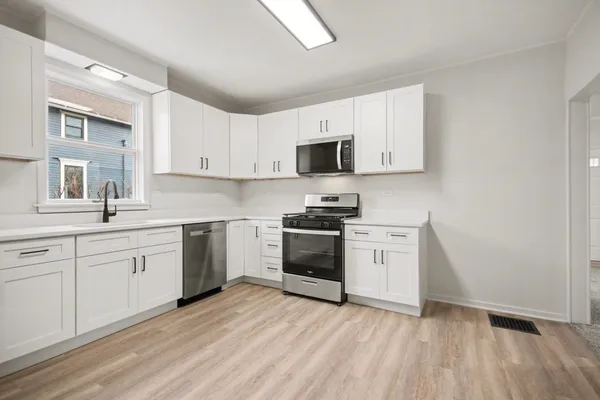 a kitchen with granite countertop white cabinets and white appliances