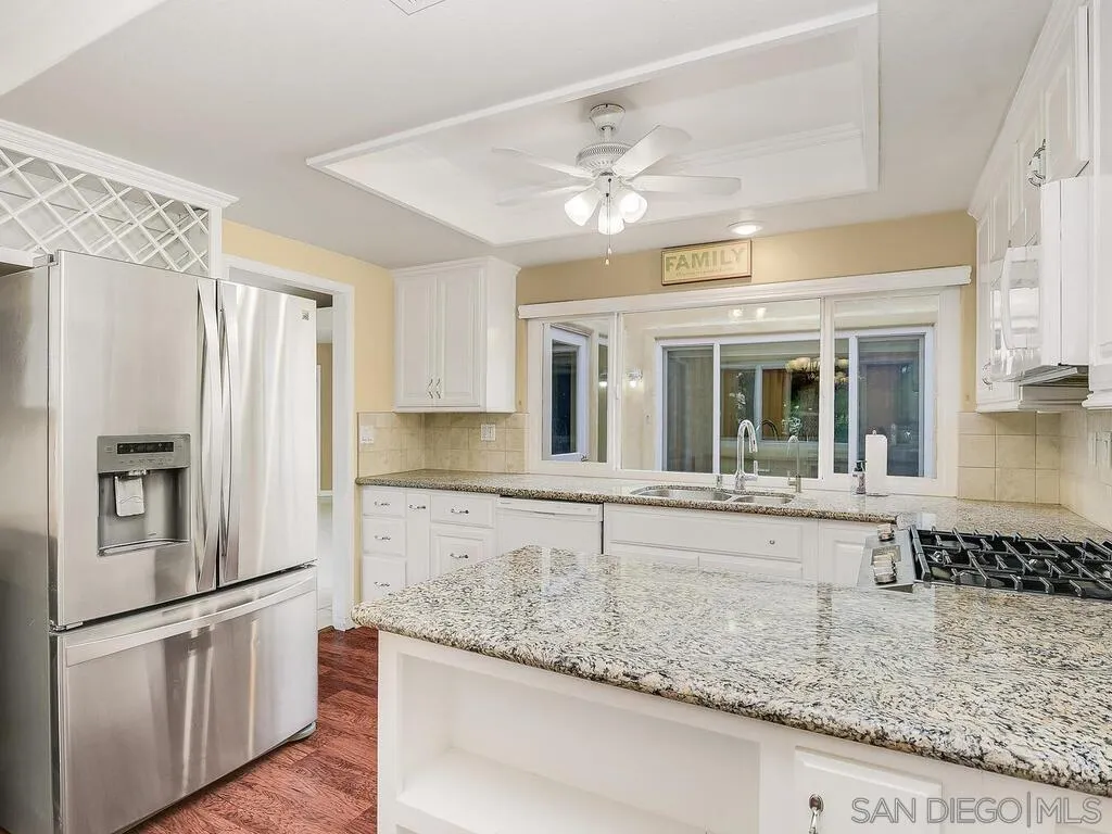 4708 Galicia Way Oceanside, CA 92056 - Photo 12 of 44 a large kitchen with granite countertop a refrigerator and a sink