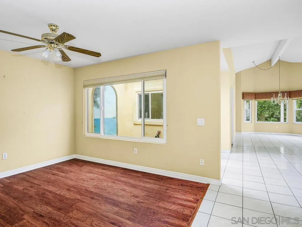 4708 Galicia Way Oceanside, CA 92056 - Photo 19 of 44 a view of an empty room with a window and wooden floor