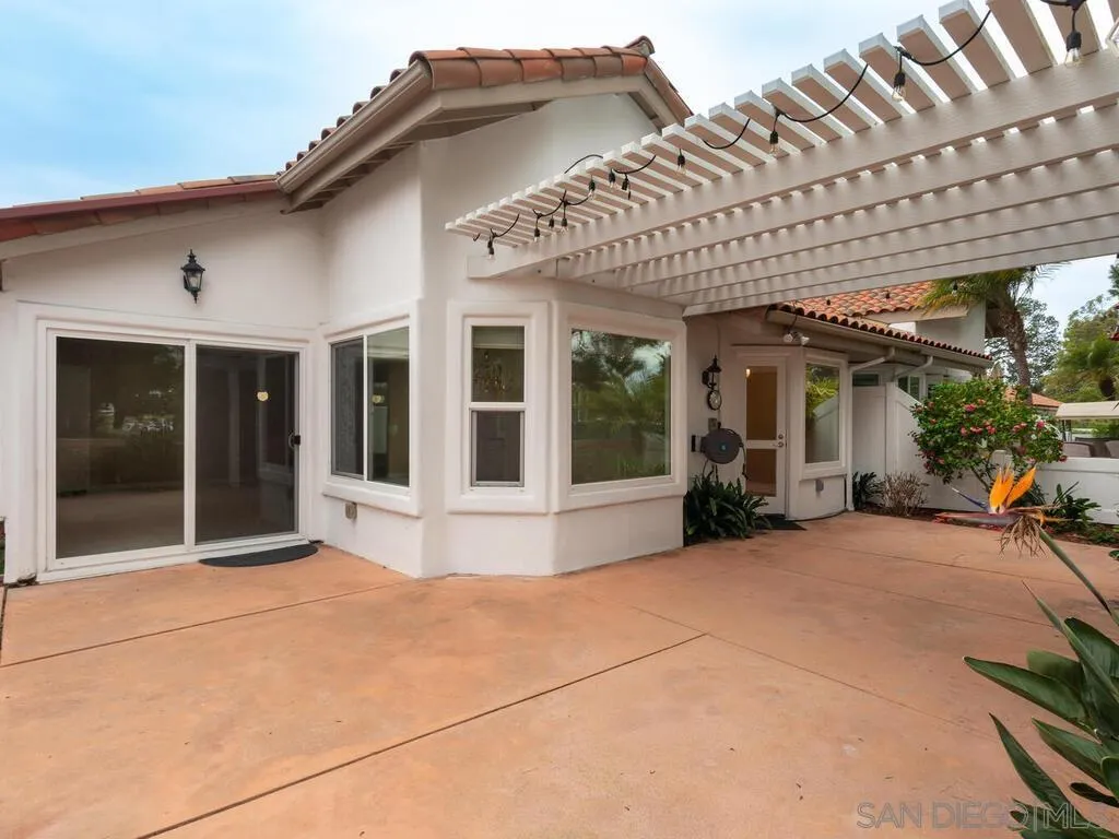 4708 Galicia Way Oceanside, CA 92056 - Photo 31 of 44 a view of a house with large windows and a small yard