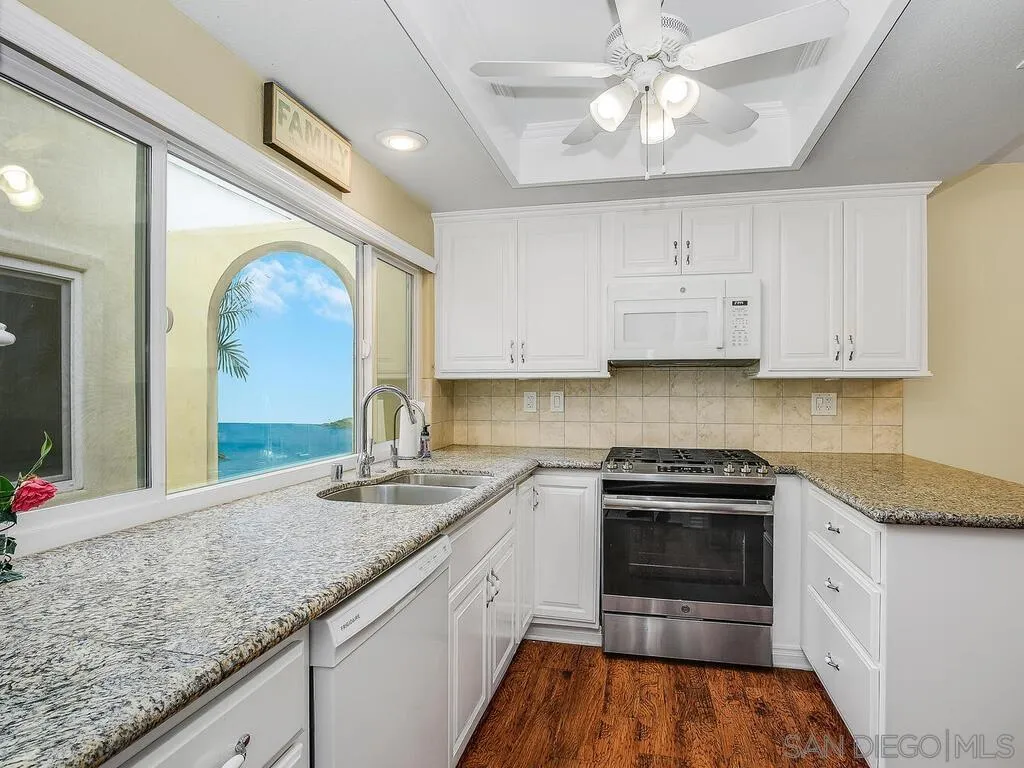 4708 Galicia Way Oceanside, CA 92056 - Photo 10 of 44 a kitchen with granite countertop a sink stainless steel appliances and cabinets