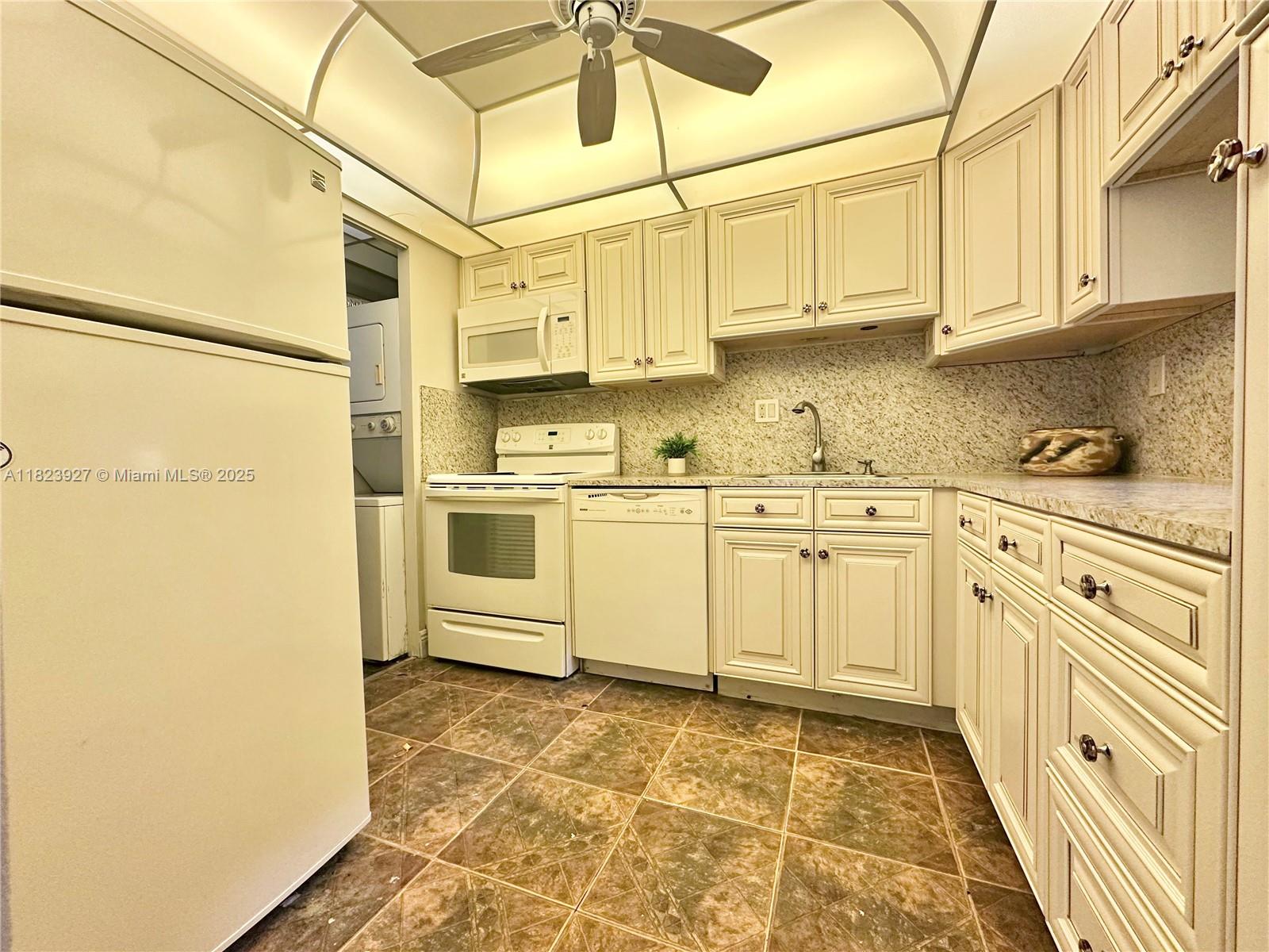 8001 Fairview Drive, Unit 107 Tamarac, FL 33321 - Photo 15 of 33 a kitchen with stainless steel appliances granite countertop a sink a stove a refrigerator and cabinets