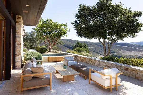 a view of a patio with couches table and chairs and potted plants