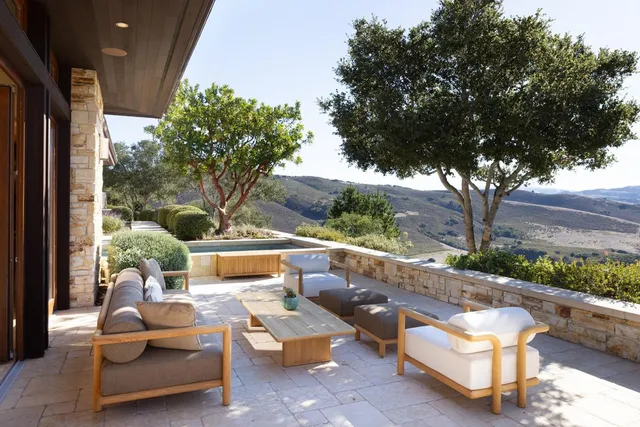 a living room with furniture kitchen view and a large window