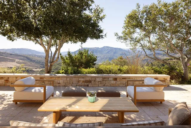 a living room with furniture fireplace and a large window