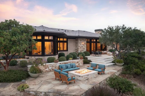 a view of a patio with couches table and chairs with potted plants