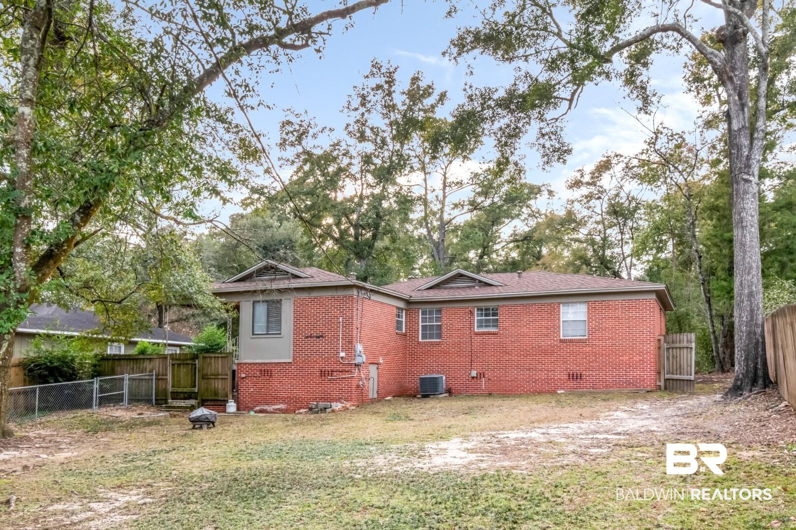 61 Nack Lane Mobile, AL 36608 - Photo 25 of 25 Back of property with central AC unit and a lawn