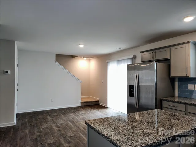 a kitchen with stainless steel appliances granite countertop a refrigerator and a sink
