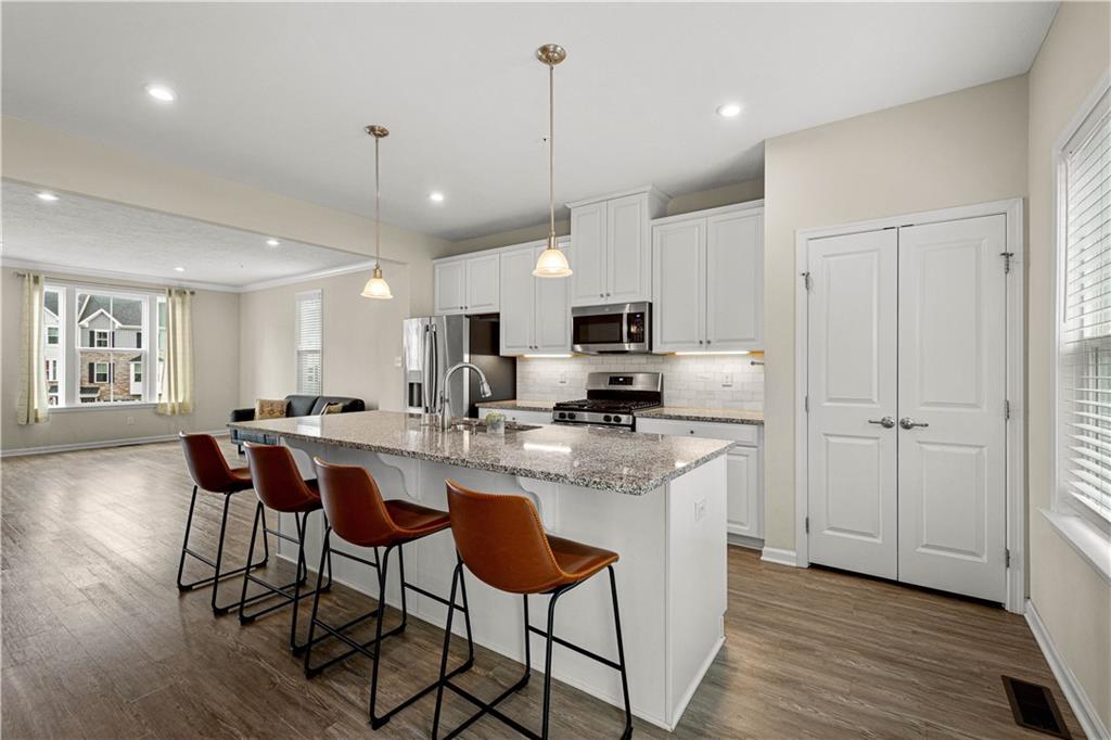 152-160 Cole Drive McKees Rocks, PA 15136 - Photo 12 of 39 a kitchen with stainless steel appliances a dining table chairs refrigerator and sink