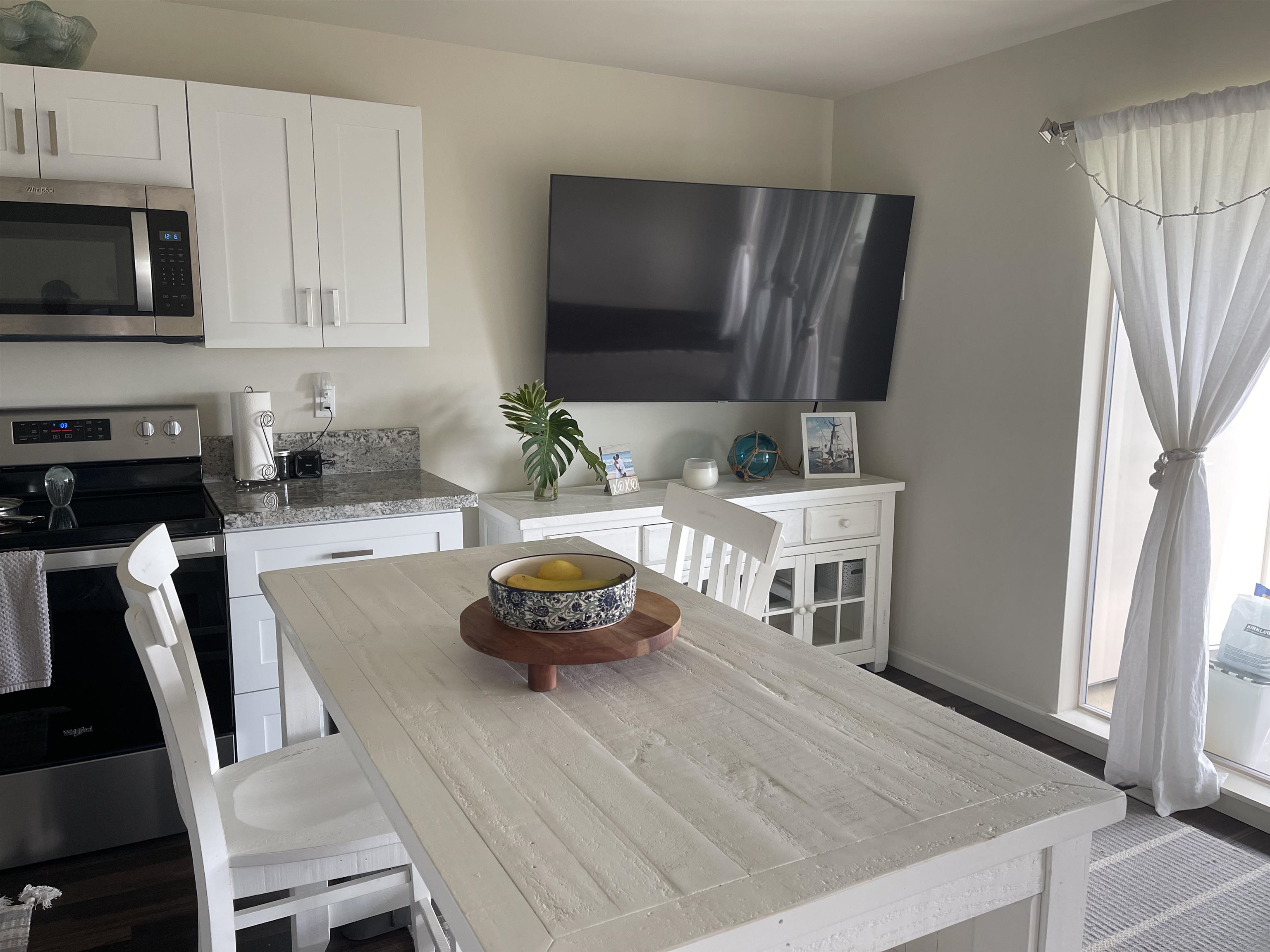 5510 Lower Honoapiilani Road, Unit C22 Lahaina, HI 96761 - Photo 6 of 13 a kitchen with a stove a microwave and wooden floor