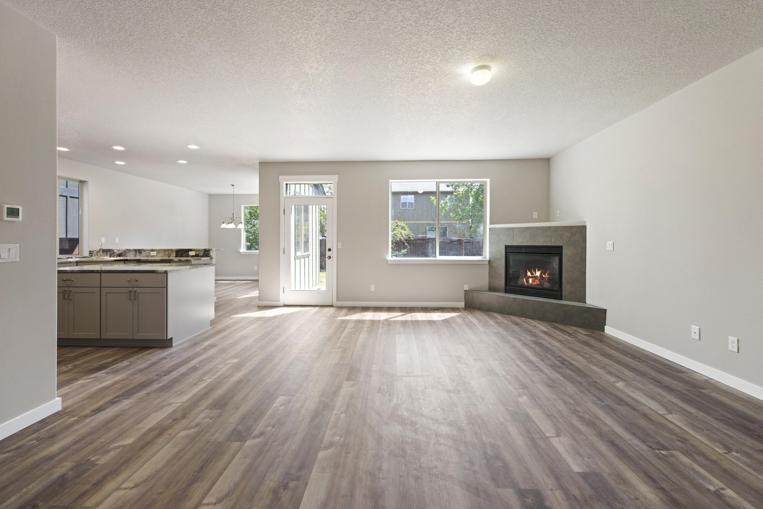 21189 Ritz Place Bend, OR 97702 - Photo 7 of 37 an empty room with wooden floor a fireplace and windows