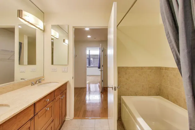 a bathroom with a tub sink and mirror