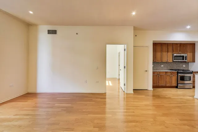 a view of kitchen with stainless steel appliances granite countertop a refrigerator a stove and a sink