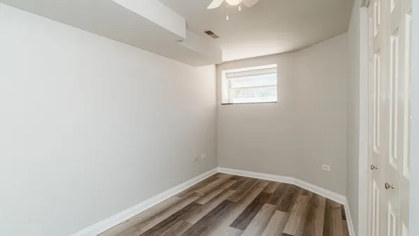 a view of an empty room with wooden floor