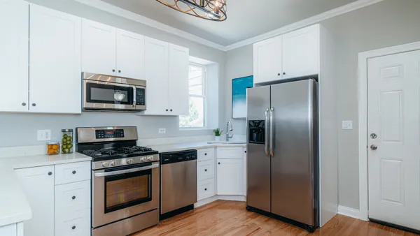 a kitchen with a sink stainless steel appliances and white cabinets