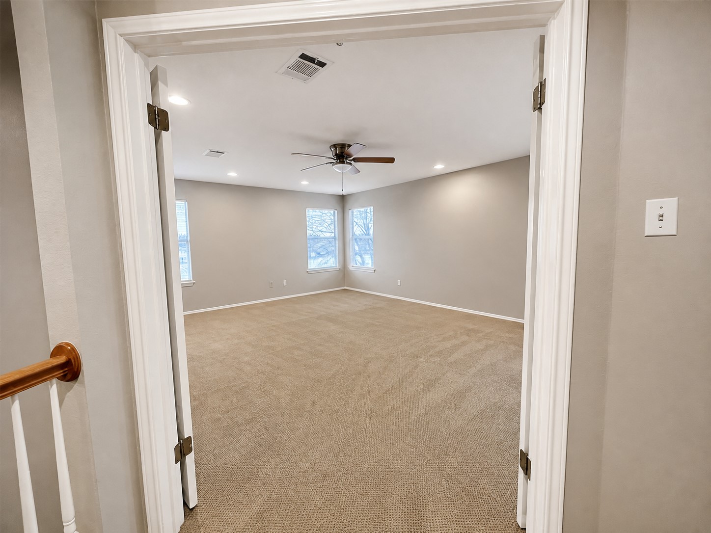 14828 Single Trace Austin, TX 78728 - Photo 12 of 30 Spacious room featuring neutral carpet flooring, light gray walls, multiple windows, recessed lighting, and a ceiling fan