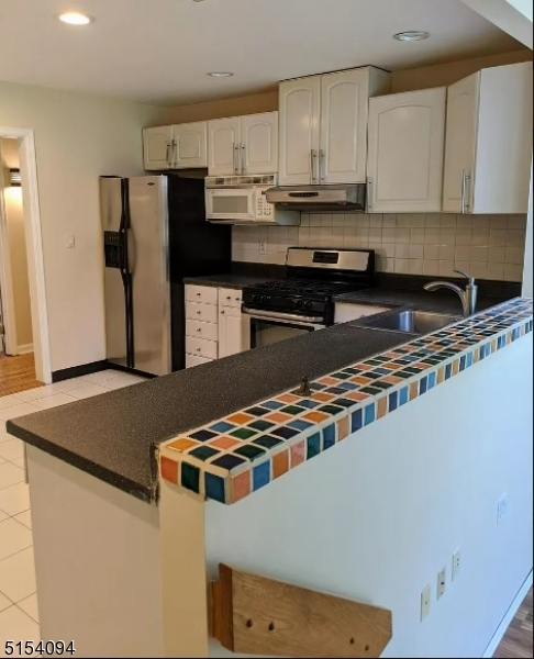 33 Roseland Avenue Warren, NJ 07059 - Photo 4 of 4 a kitchen with stainless steel appliances granite countertop a refrigerator a stove and a sink