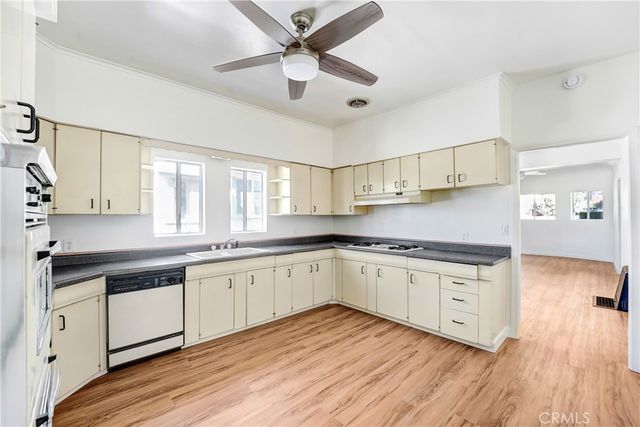 a kitchen with stainless steel appliances granite countertop wooden floors and view living room