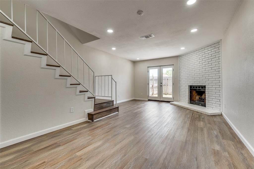 709 Lee Street, Unit 3 Mesquite, TX 75149 - Photo 4 of 9 a view of an empty room with wooden floor fireplace and a window