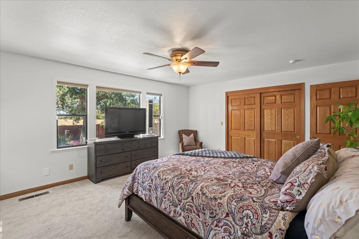 14325 Monterey Road Morgan Hill, CA 95037 - Photo 19 of 41 a bedroom with a large bed and a chandelier fan