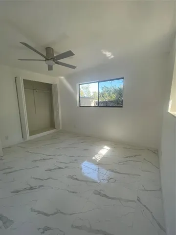 en empty room with windows and fan
