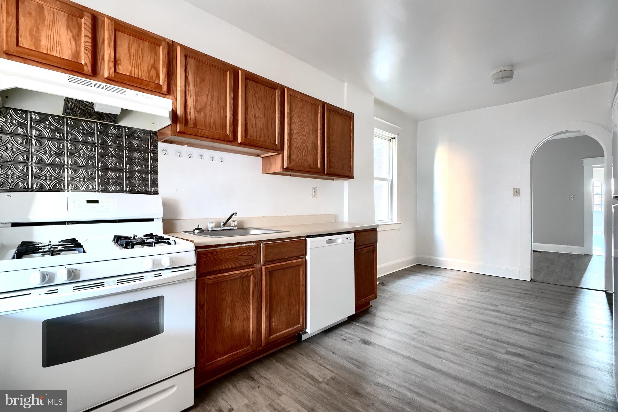 5106 Harford Road Baltimore, MD 21214 - Photo 12 of 23 a kitchen with wooden cabinets and a stove top oven