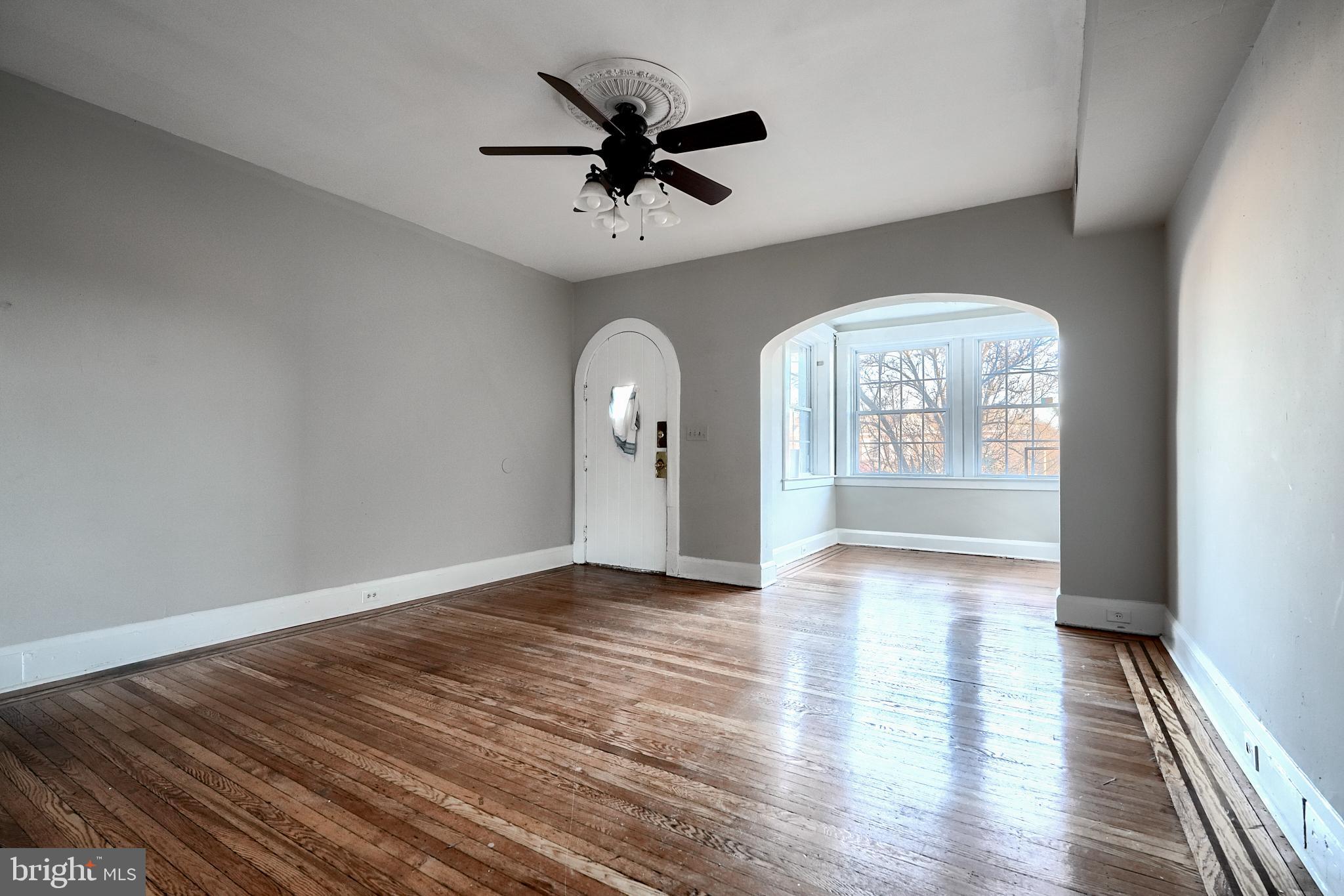 5106 Harford Road Baltimore, MD 21214 - Photo 8 of 23 an empty room with wooden floor chandelier and windows
