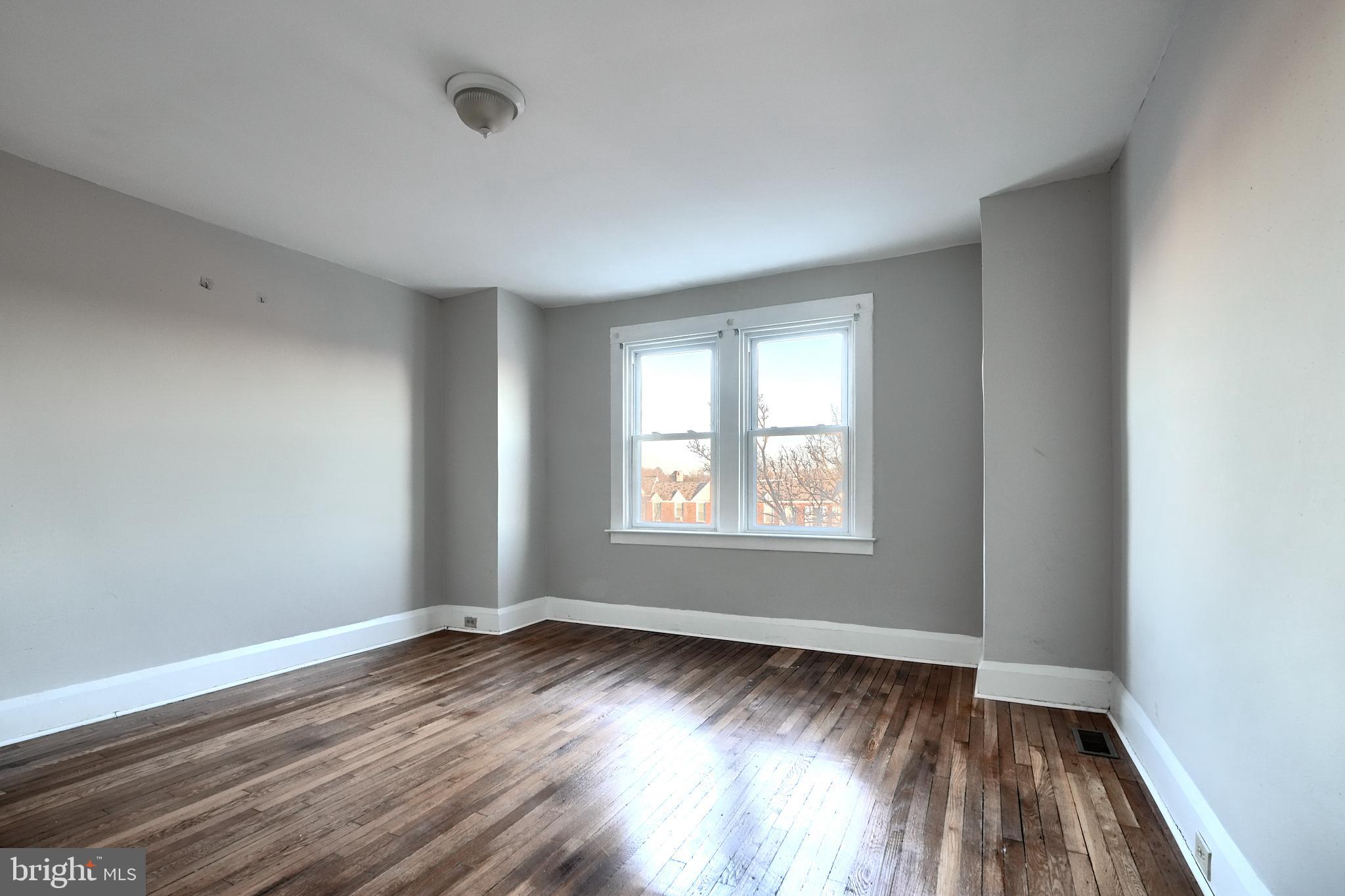 5106 Harford Road Baltimore, MD 21214 - Photo 10 of 23 an empty room with wooden floor and windows