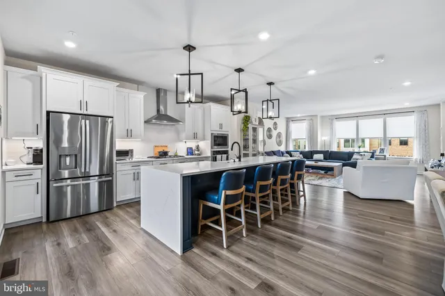 a kitchen with stainless steel appliances kitchen island granite countertop a stove a sink and a refrigerator