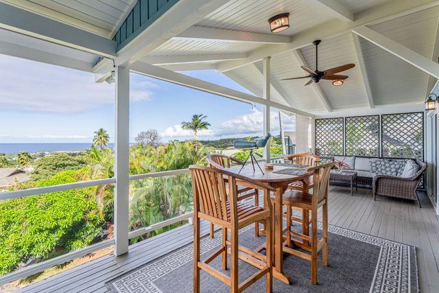 a living room with patio furniture and a chandelier