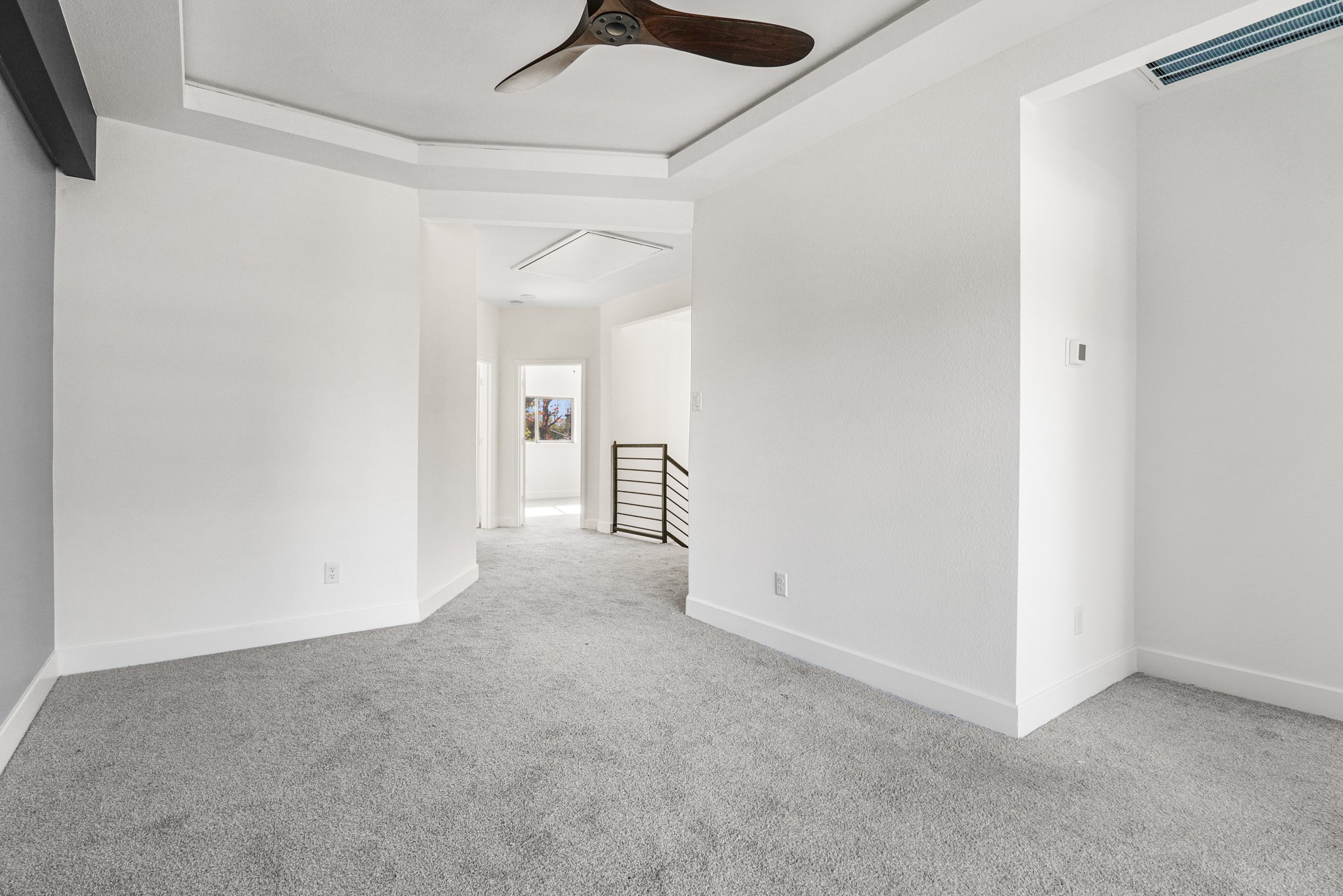 8046 Chateau Street Houston, TX 77028 - Photo 12 of 22 Bright and spacious room with neutral carpet, modern ceiling fan, and an open hallway leading to another area. Ideal for a cozy living space or office.