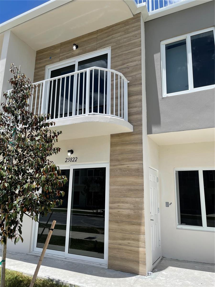 a view of a house that has a small deck
