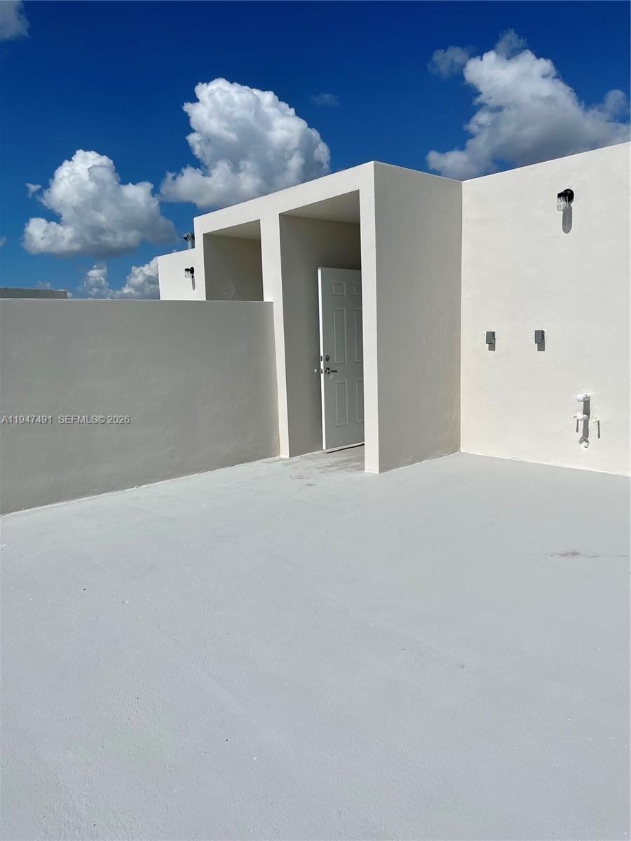 25822 Southwest 144th Court, Unit 25822 Homestead, FL 33032 - Photo 18 of 19 a view of a white wall with a potted plant on it