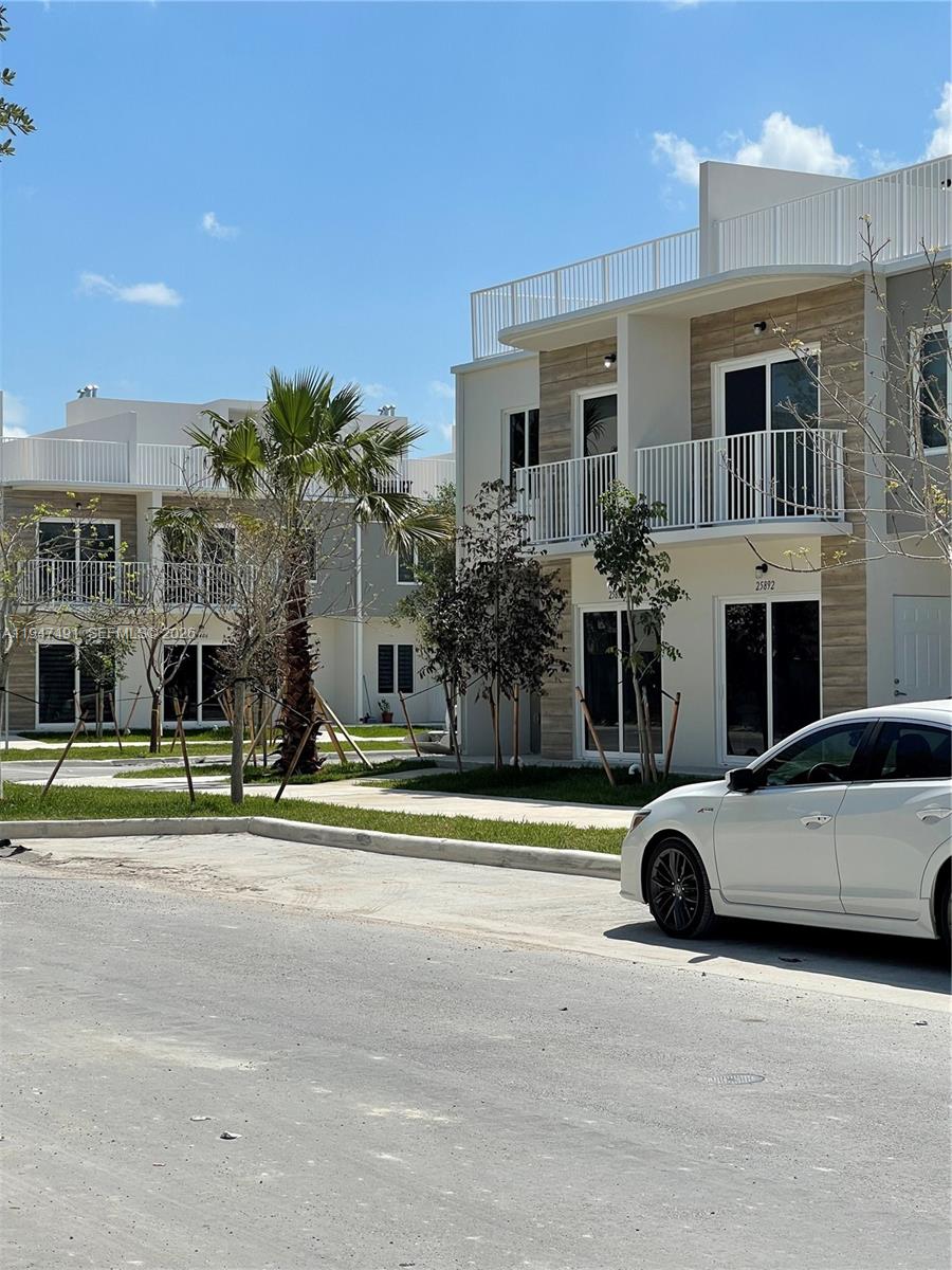 25822 Southwest 144th Court, Unit 25822 Homestead, FL 33032 - Photo 2 of 19 a view of a car parked in front of a building
