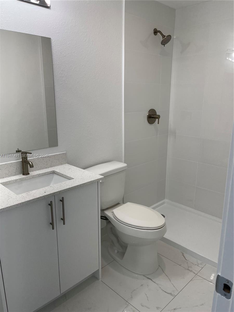 25822 Southwest 144th Court, Unit 25822 Homestead, FL 33032 - Photo 10 of 19 a bathroom with a sink toilet and shower