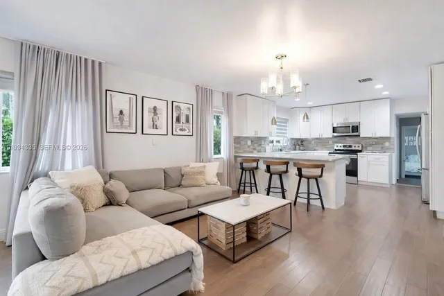 a living room with furniture and kitchen view