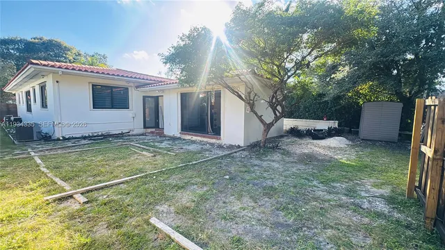 a view of a house with backyard and trees