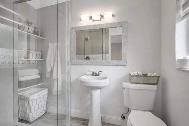 a bathroom with a sink toilet and a mirror