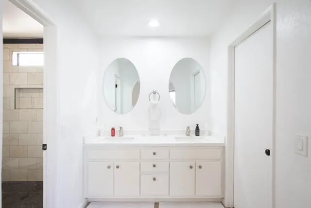 a bathroom with a double vanity sink and a mirror