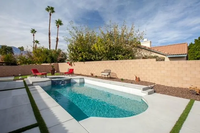 a view of a swimming pool with a yard and sitting area