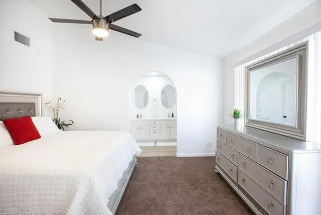 a bedroom with a bed and a mirror on the dresser