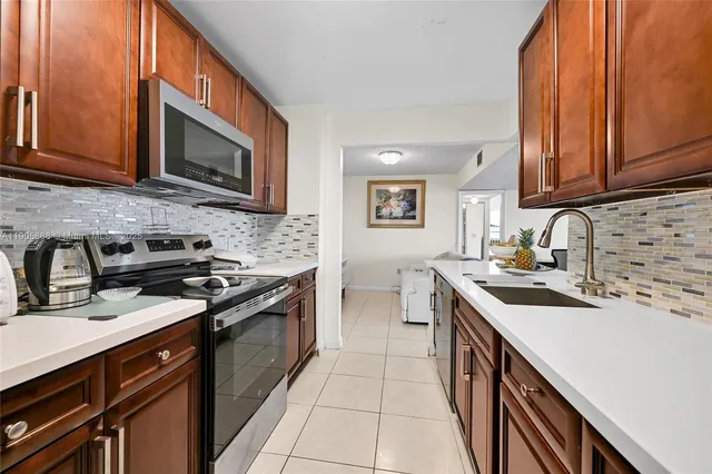 a kitchen with stainless steel appliances a stove sink microwave and cabinets