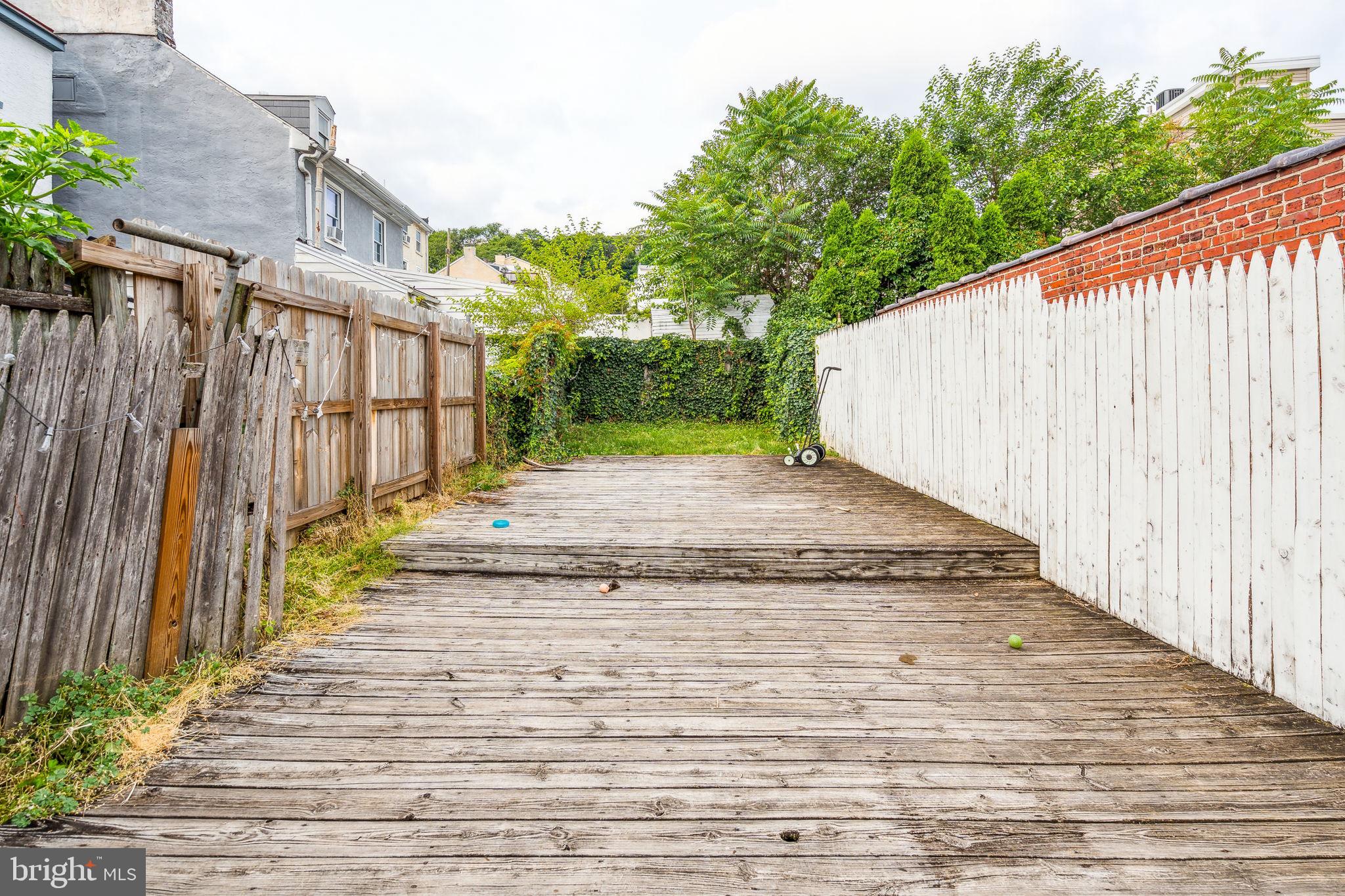 a view of a pathway with a wooden fence