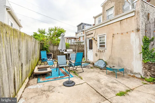 a view of a patio with couple of chairs and potted plants