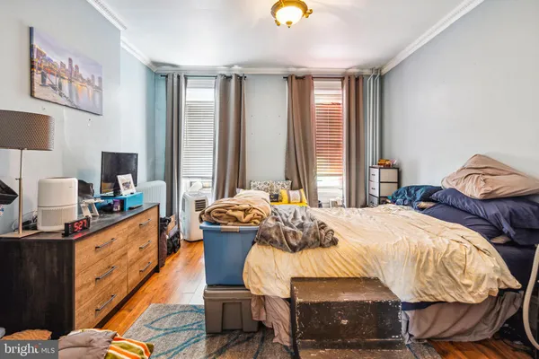 a bedroom with a bed and wooden floor