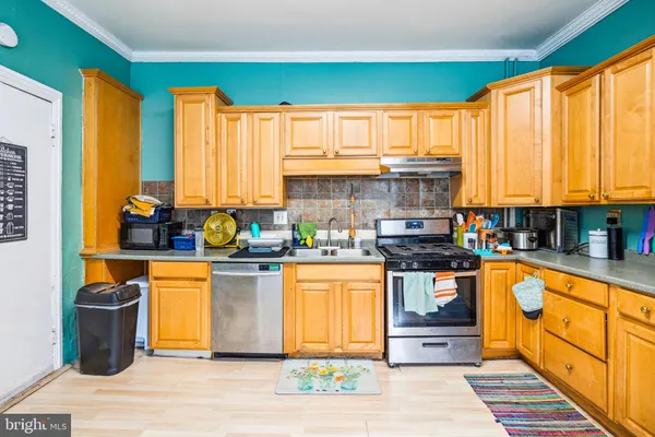 a kitchen with stainless steel appliances granite countertop a stove a sink and a microwave