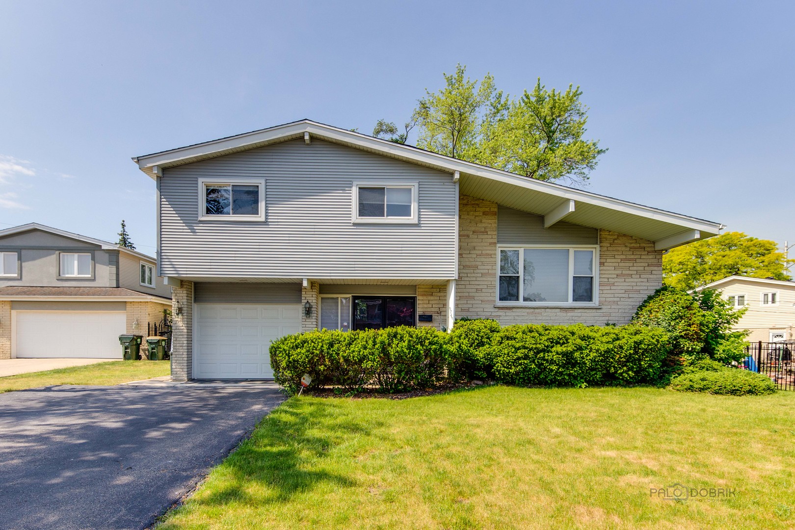9747 Huber Ovl Niles, IL 60714 - Photo 1 of 38 a front view of a house with a yard and garage