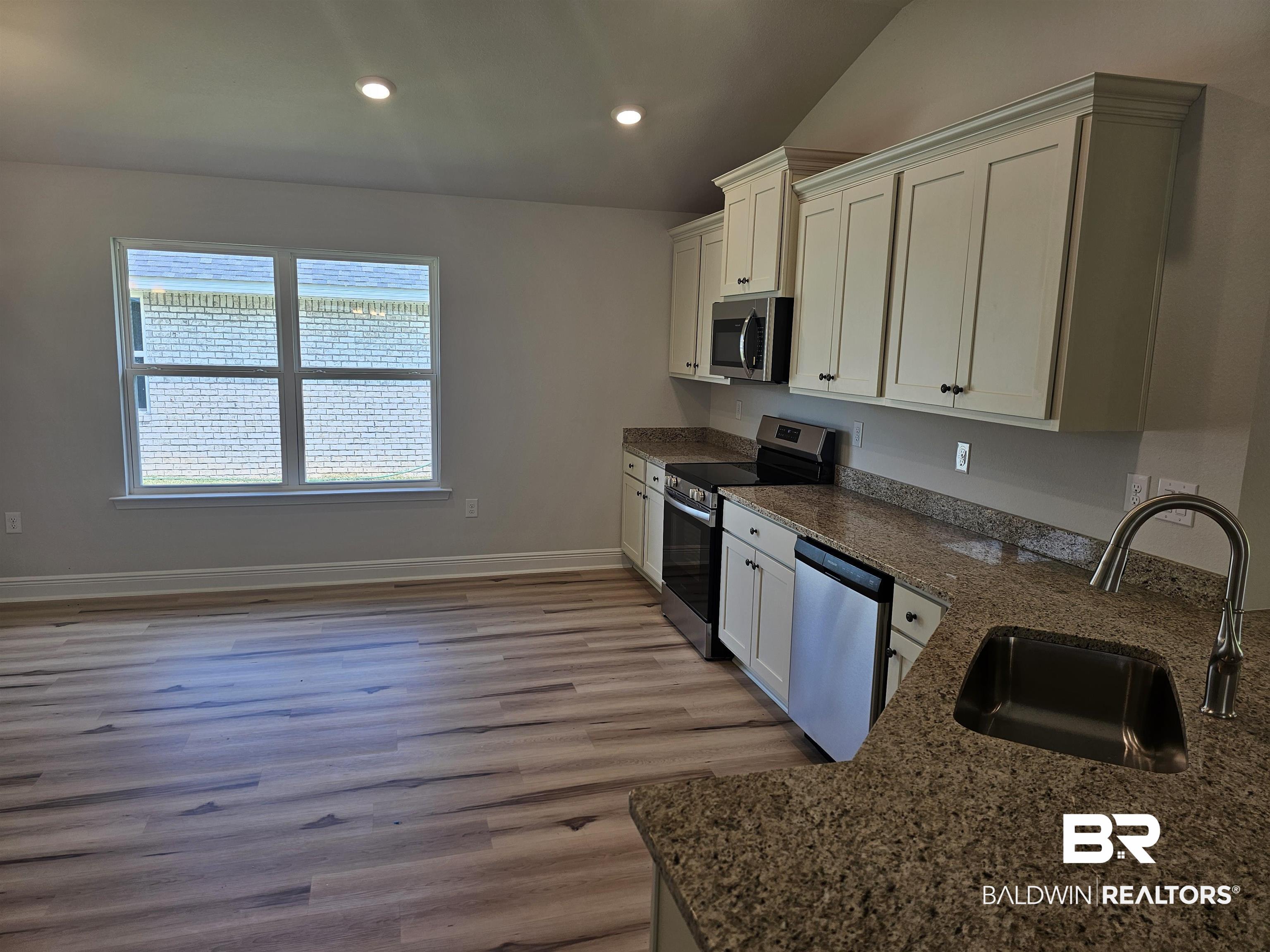 650 Revere Street Foley, AL 36535 - Photo 30 of 34 Kitchen featuring white cabinets, stainless steel appliances, light wood-type flooring, and sink