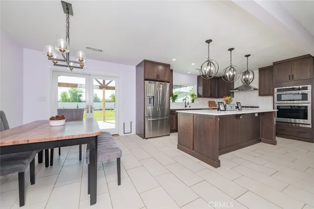 a kitchen with stainless steel appliances a table chairs and a refrigerator